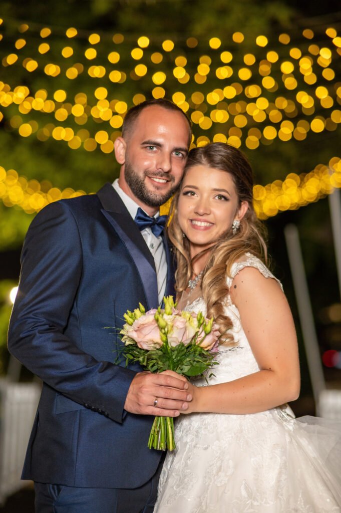 Esküvői portré fényfüzérek alatt – romantikus pillanat