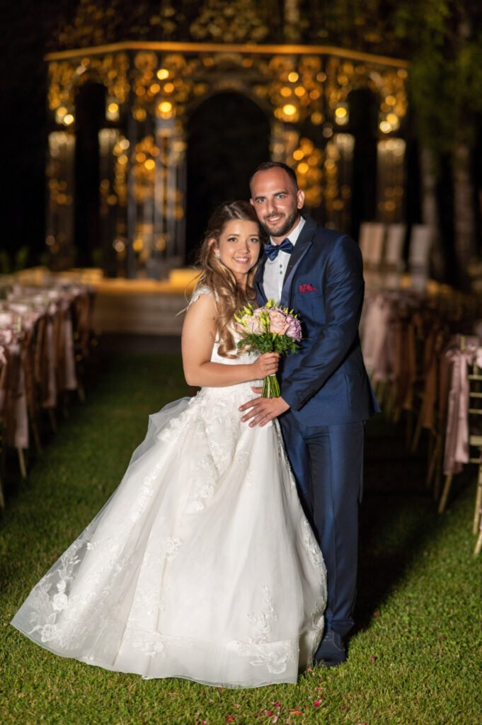 Romantikus esküvői portré fényárban úszó pavilon előtt