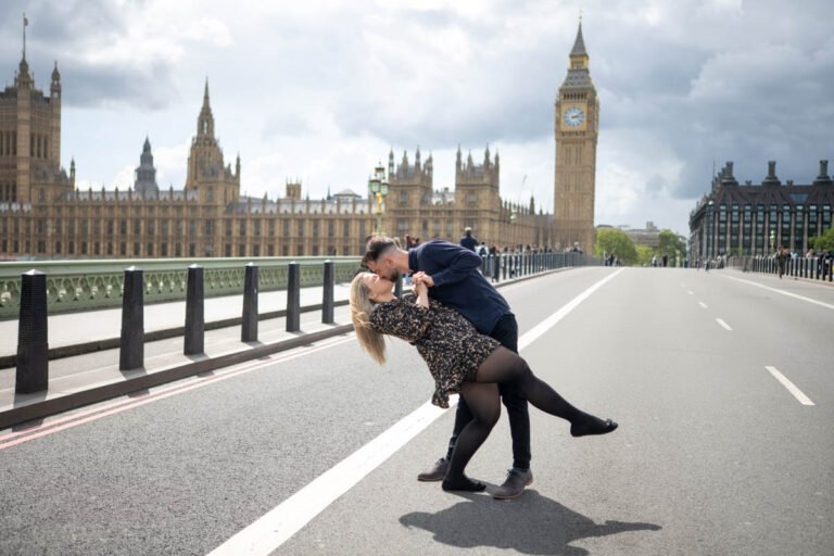 Esküvői páros fotózás Londonban – Egy szerelmes pár szenvedélyes csókja a Westminster hídon, a Big Bennel a háttérben. Meghitt és filmes hangulatú jegyesfotózás különleges esküvői emlékekhez.
