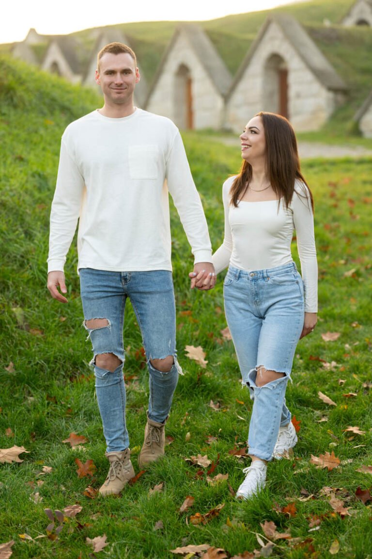 Esküvői jegyesfotózás a Kőporosi pincesoron, Hercegkúton – Egy szerelmes pár kéz a kézben sétál az őszi tájban, festői borospincék között. Meghitt és természetes fotózás különleges esküvői emlékekhez.