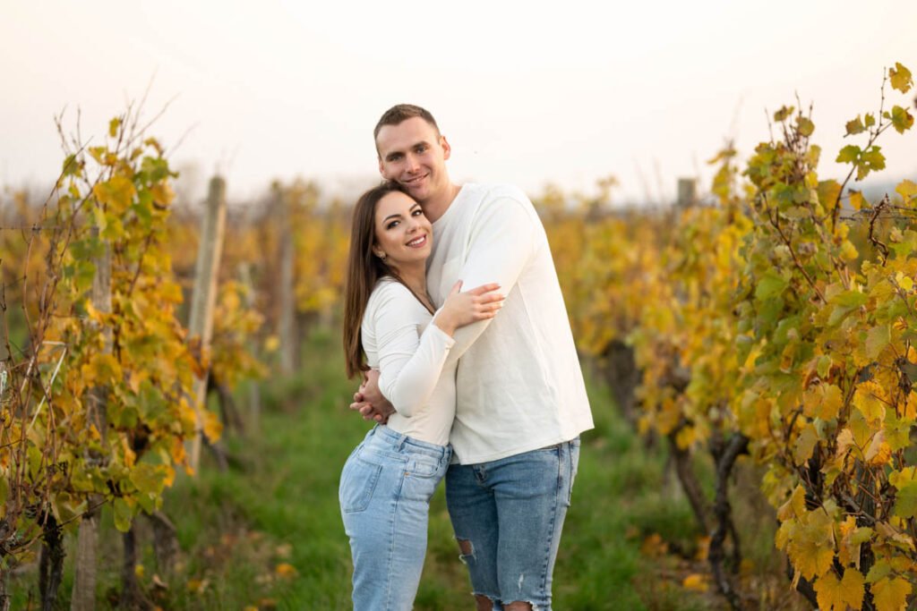 Esküvői páros fotózás a természetben – Egy boldog szerelmes pár ölelése egy őszi szőlőskertben, naplemente fényében. Meghitt és érzelemdús jegyesfotózás különleges esküvői emlékekhez.