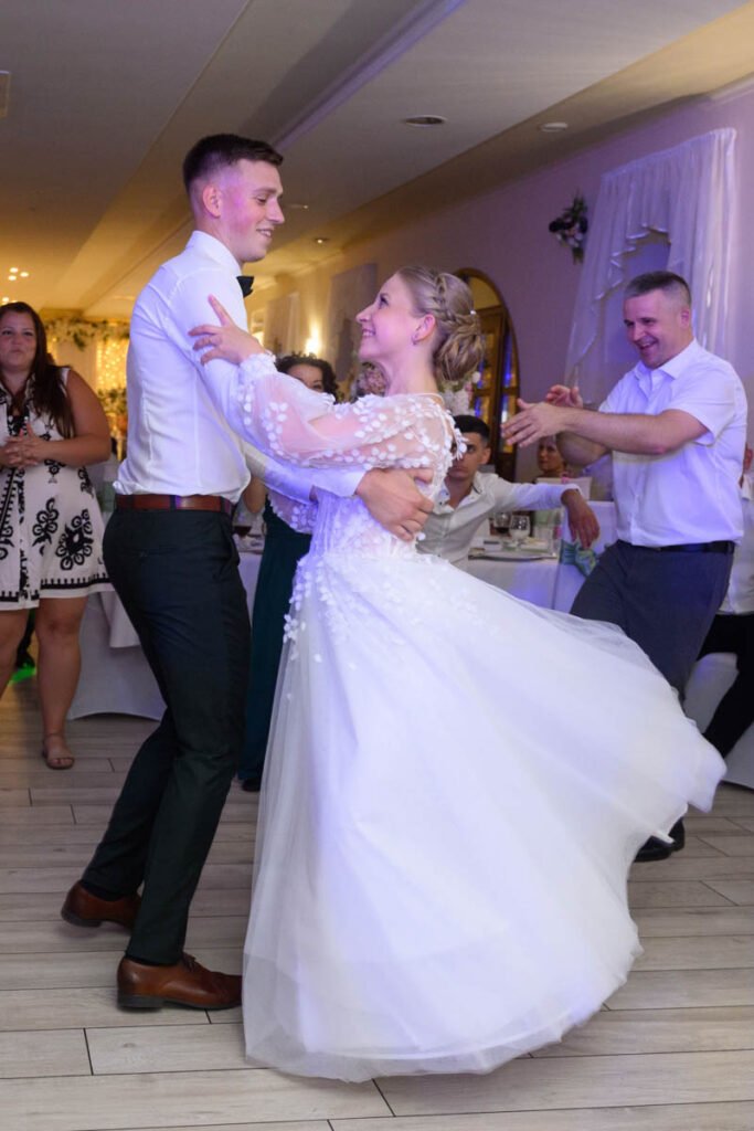 Az ifjú pár tánca a vendégek körében, a menyasszony ruhája lebeg